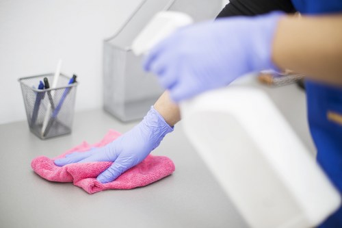 Cleaner preparing oven cleaning equipment safely in a kitchen